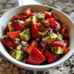 Close-up of vibrant Strawberry Avocado Balsamic Salsa featuring chunks of fresh strawberries, avocado, and red onion.