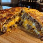 Cross-section view of amazing garbage bread stuffed with seasoned ground beef and gooey melted cheddar cheese.
