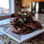 Stack of rich, fudgy Andes mint cookies, showing the gooey green mint filling inside the broken top cookie.