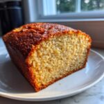 Close-up of a slice of the best banana bread showing its moist, open crumb and deeply browned crust.
