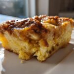 Close-up of a moist slice of caramel apple dump cake with a gooey, caramelized topping.