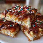 Close-up of stacked caramel ritz cracker christmas cookies topped with chocolate drizzle and sprinkles.