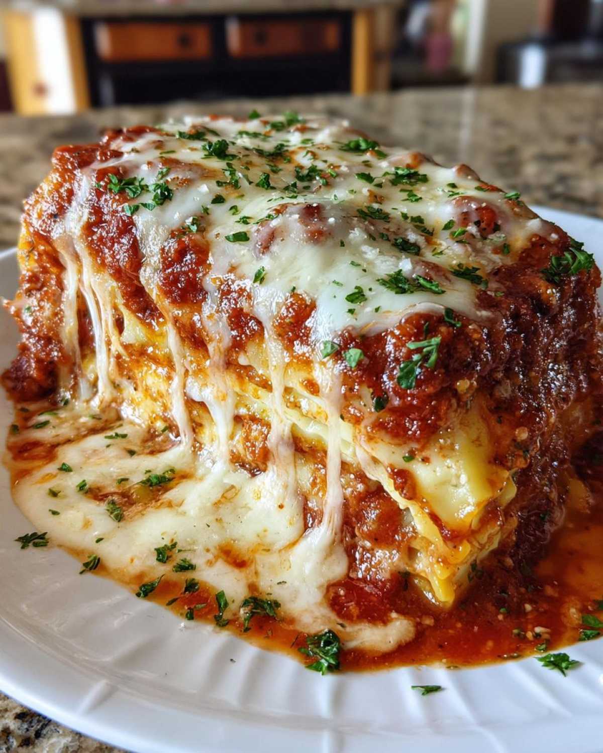 A close-up of a hearty slice of cheesy baked ravioli smothered in marinara sauce and melted mozzarella.