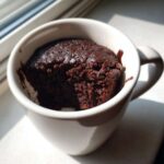 A rich, dark chocolate Cottage Cheese Microwave Brownie baked inside a white ceramic mug.