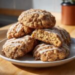 A stack of freshly baked coffee cake cookies with a cinnamon crumb texture and white glaze drizzle.
