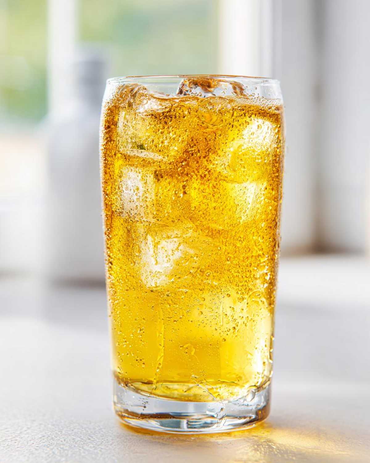 A tall, sweating glass filled with golden lemonade and ice cubes, perfect for a refreshing lemonade recipe.