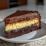 A decadent slice of Italian love cake showing three distinct layers: dark chocolate cake, creamy yellow filling, and chocolate frosting.