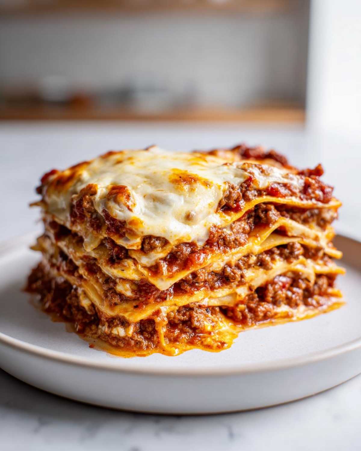 A tall, cheesy slice of classic lasagna with meat sauce, despite the article being about mexican pizza.