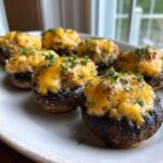 Close-up of several Air Fryer Cheddar Stuffed Mushrooms, topped with melted cheese and parsley.