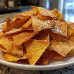 A white bowl filled with golden brown Air Fryer Crispy Tortilla Strips sprinkled with salt.