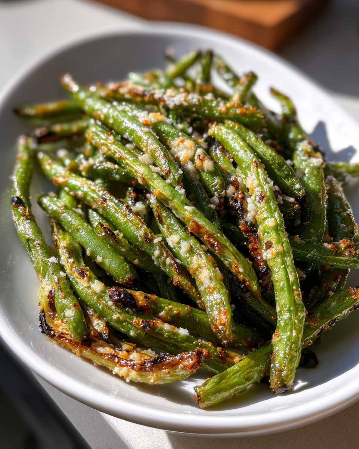 Close-up of crispy Air Fryer Garlic Parmesan Green Beans topped with grated cheese.