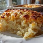 Close-up of a serving of amazing cheesy potato casserole with a golden-brown, bubbly cheese crust.