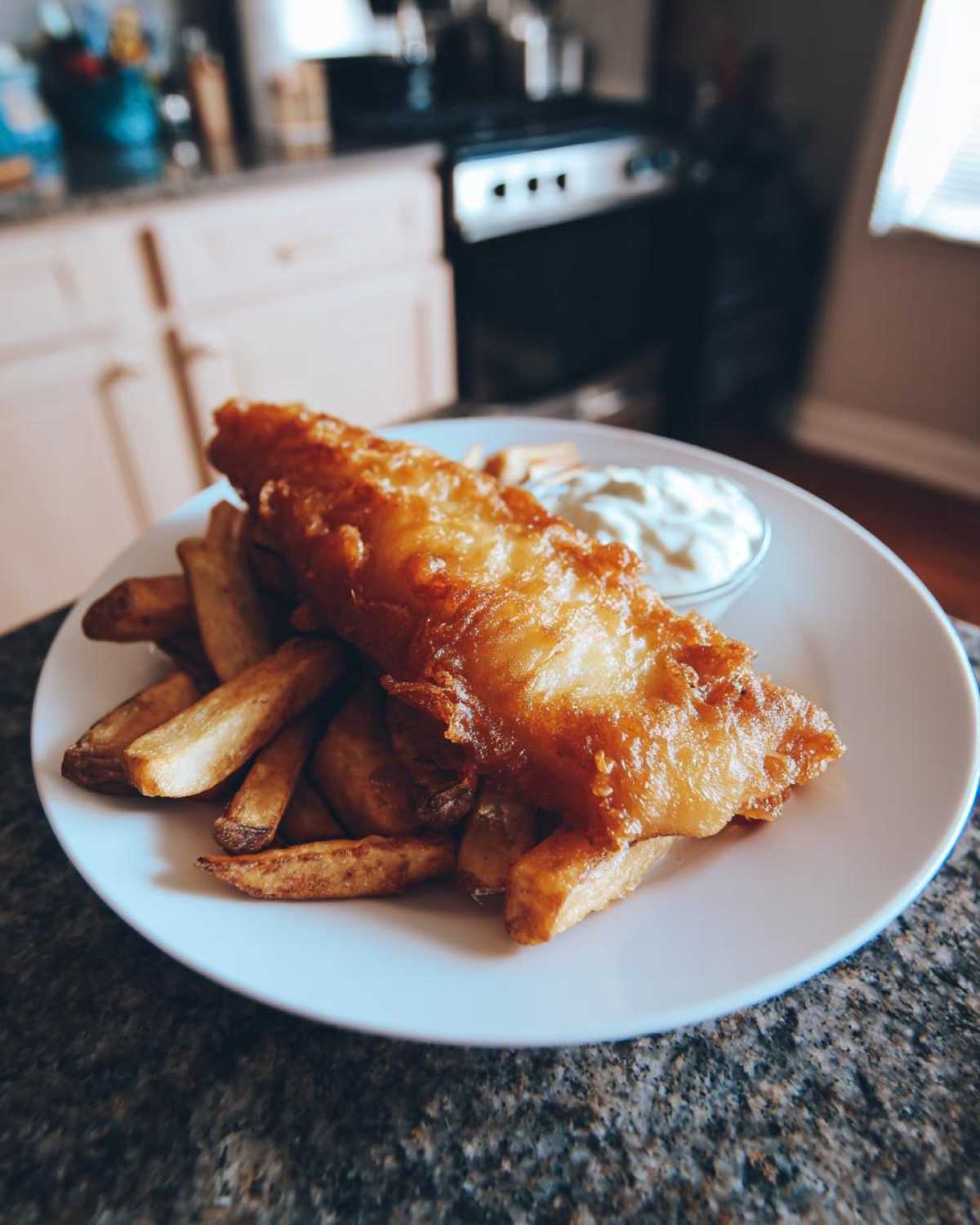 Golden, crispy battered fish served over thick-cut chips with a side of tartar sauce, perfect Copycat Pub-Style Fish and Chips.
