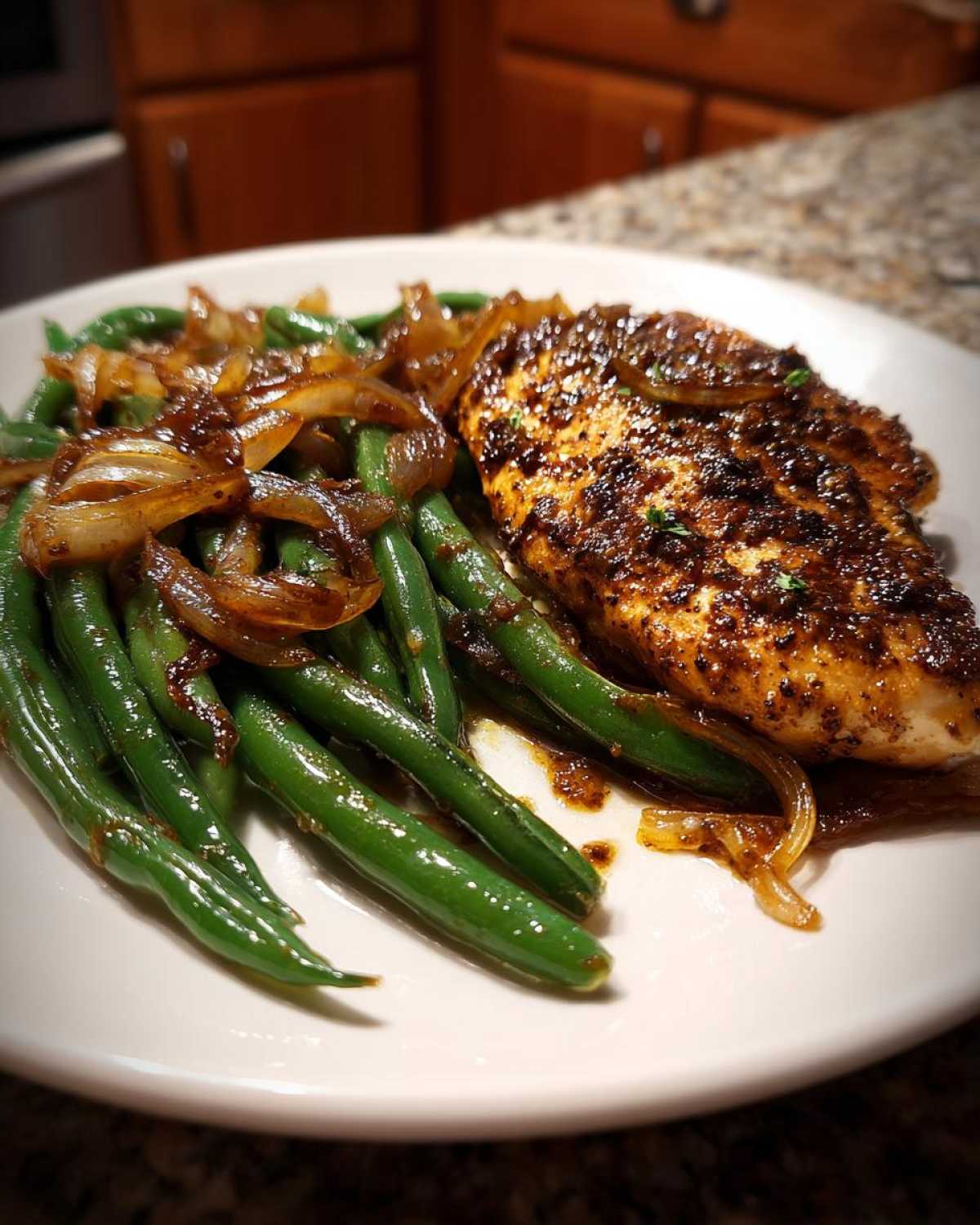 A plated serving of One-Pan Dijon Chicken with green beans and caramelized shallots.