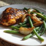 A plated serving of One-Pan Dijon Chicken with green beans and caramelized shallots, glistening under natural light.