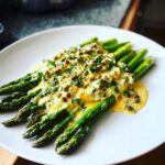 Bright green asparagus spears generously topped with rich yellow Sauce Gribiche and capers.
