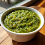 Close-up of a chunky, vibrant green Authentic Salsa Verde Recipe served in a small white bowl.