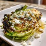 A perfectly cooked, thick slice of Blistered Cabbage Steaks with Feta sprinkled on top.