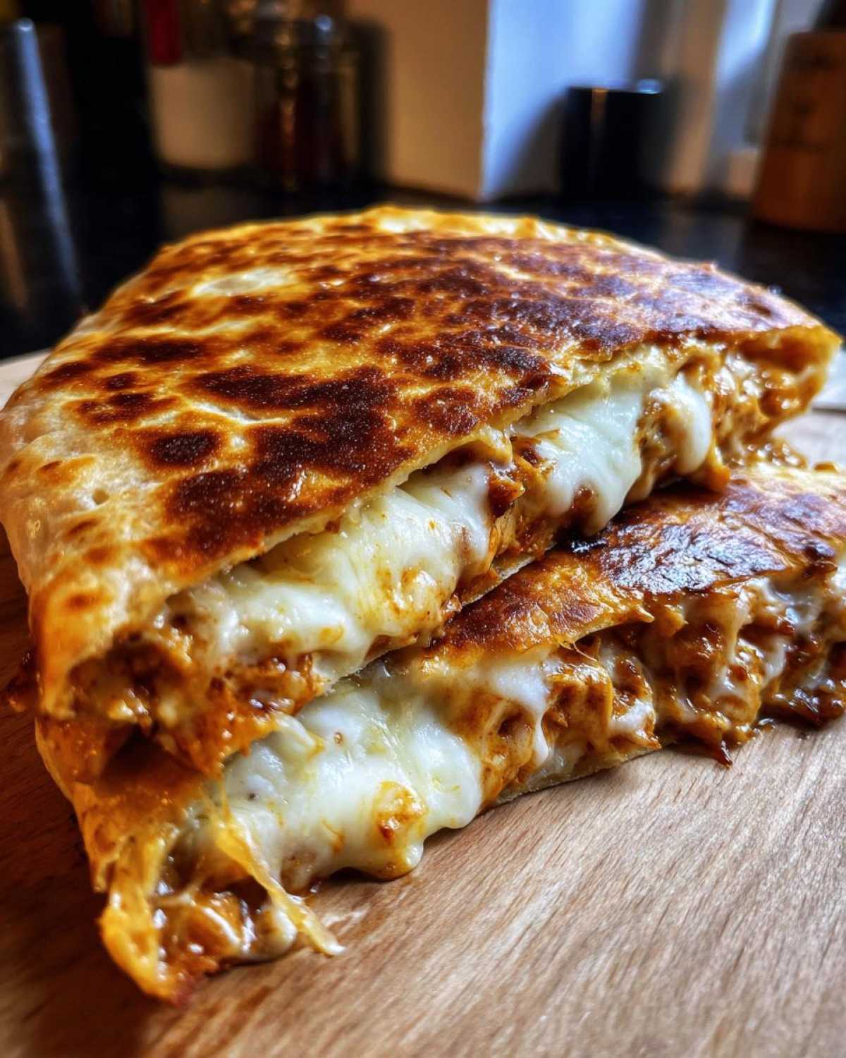 Close-up of a perfectly grilled buffalo chicken quesadilla cut in half, showing melted white cheese and spicy filling.