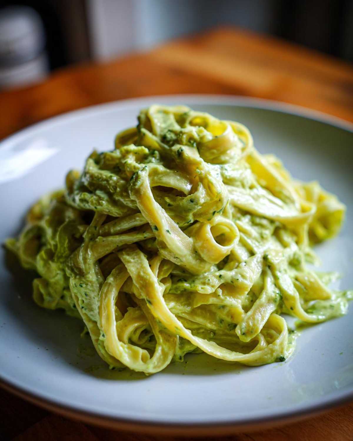 Close-up of fettuccine pasta generously coated in a creamy green Cabbage Alfredo Pasta Sauce.