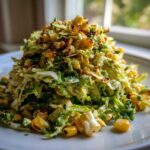 A mound of creamy Cabbage and Corn Salad Grilled served on a white plate, featuring charred corn kernels.