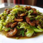 Close-up of Cabbage and Pork Stir Fry Ginger, featuring bright green cabbage and caramelized pork pieces in a savory sauce.