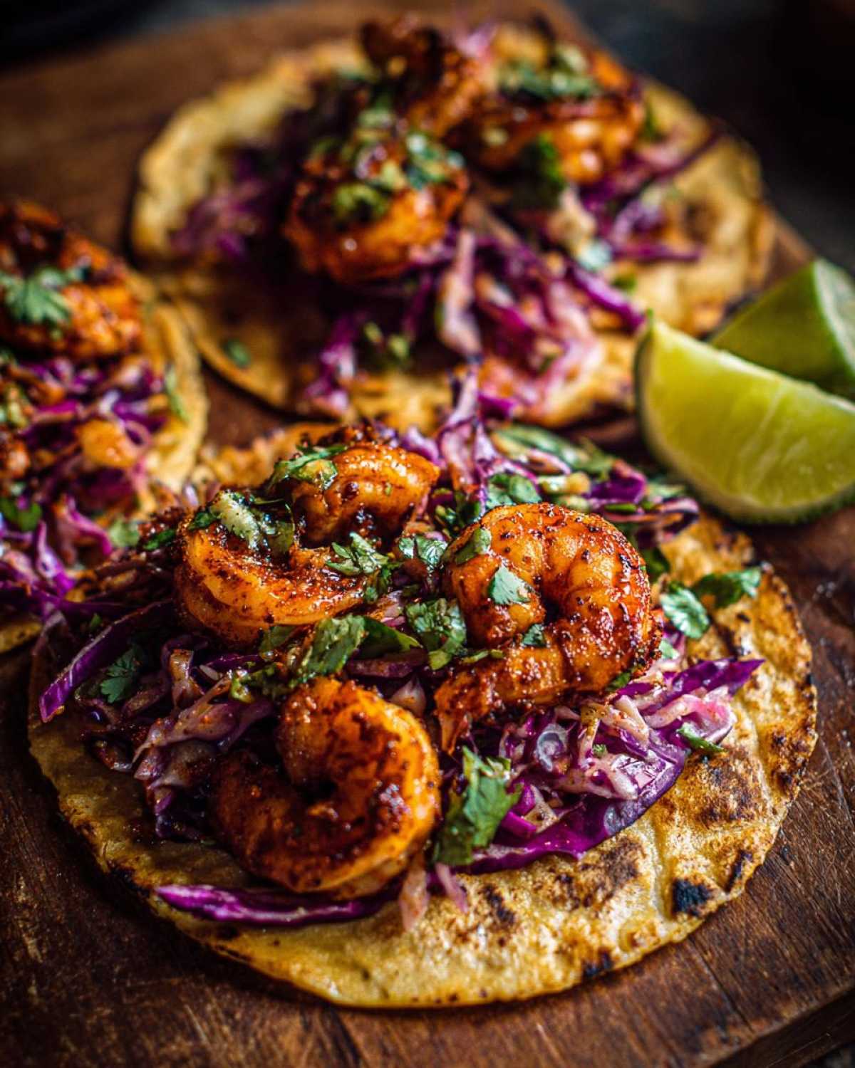Close-up of delicious Cabbage and Shrimp Tacos topped with seasoned shrimp and red cabbage slaw.