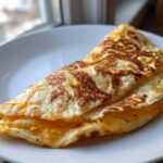 A folded, golden-brown cheesy pocket tacos creation resting on a white plate near a window.