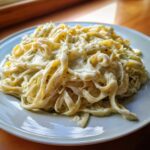 Close-up of fettuccine pasta generously coated in creamy Cabbage Alfredo Pasta Sauce on a white plate.