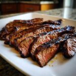 Close-up of medium-rare sliced Flank Steak with Soy Marinade, showing a caramelized crust and juicy interior.