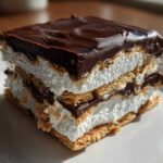 A square slice of Frozen S’mores Cool Chocolate Marshmallow dessert with layers of graham cracker, marshmallow, and chocolate ganache.