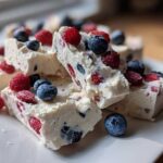 Close-up of thick, creamy slices of Frozen Yogurt Bark with Spring Berries, topped with fresh blueberries and raspberries.