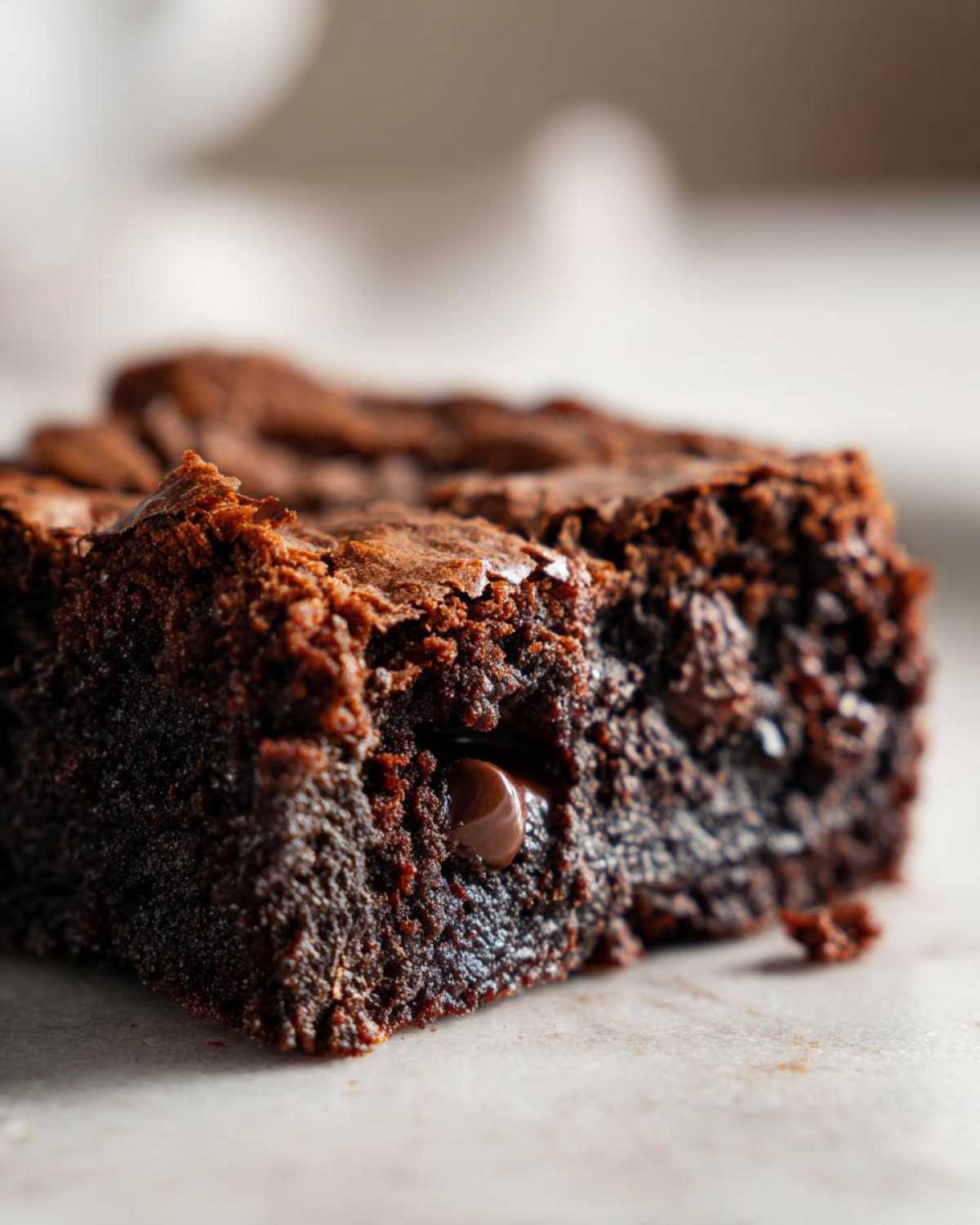A close-up, macro shot of a rich, fudgy piece of chocolate cobbler showing a melted chocolate chip.