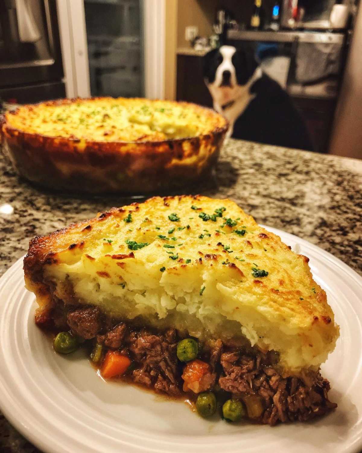 A thick slice of Leftover Lamb Shepherd's Pie showing shredded lamb, peas, and carrots under a browned mashed potato topping.