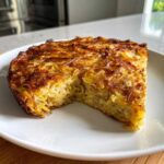 A golden-brown slice of Leftover Spaghetti Frittata showing the tightly packed noodles and crispy, baked top.