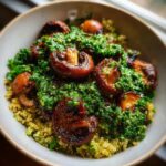 A close-up view of savory Mushroom Bowls with Kale Pesto served over a bed of golden quinoa in a light-colored bowl.