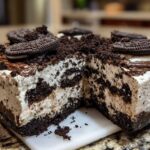 A slice removed from a no-bake dirt cake showing the creamy white filling mixed with dark chocolate cookie crumbs.