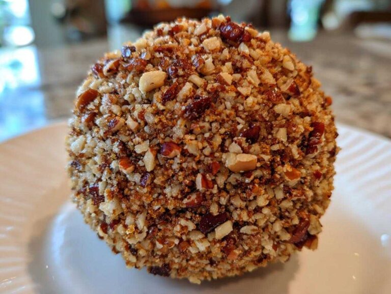 Amazing 5-Minute cheese ball recipe Close-up of a perfectly formed cheese ball recipe coated entirely in finely chopped, toasted pecans.