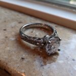 Close-up of a stunning solitaire engagement ring with intricate filigree detailing, part of the process to Create Your Dream Ring.
