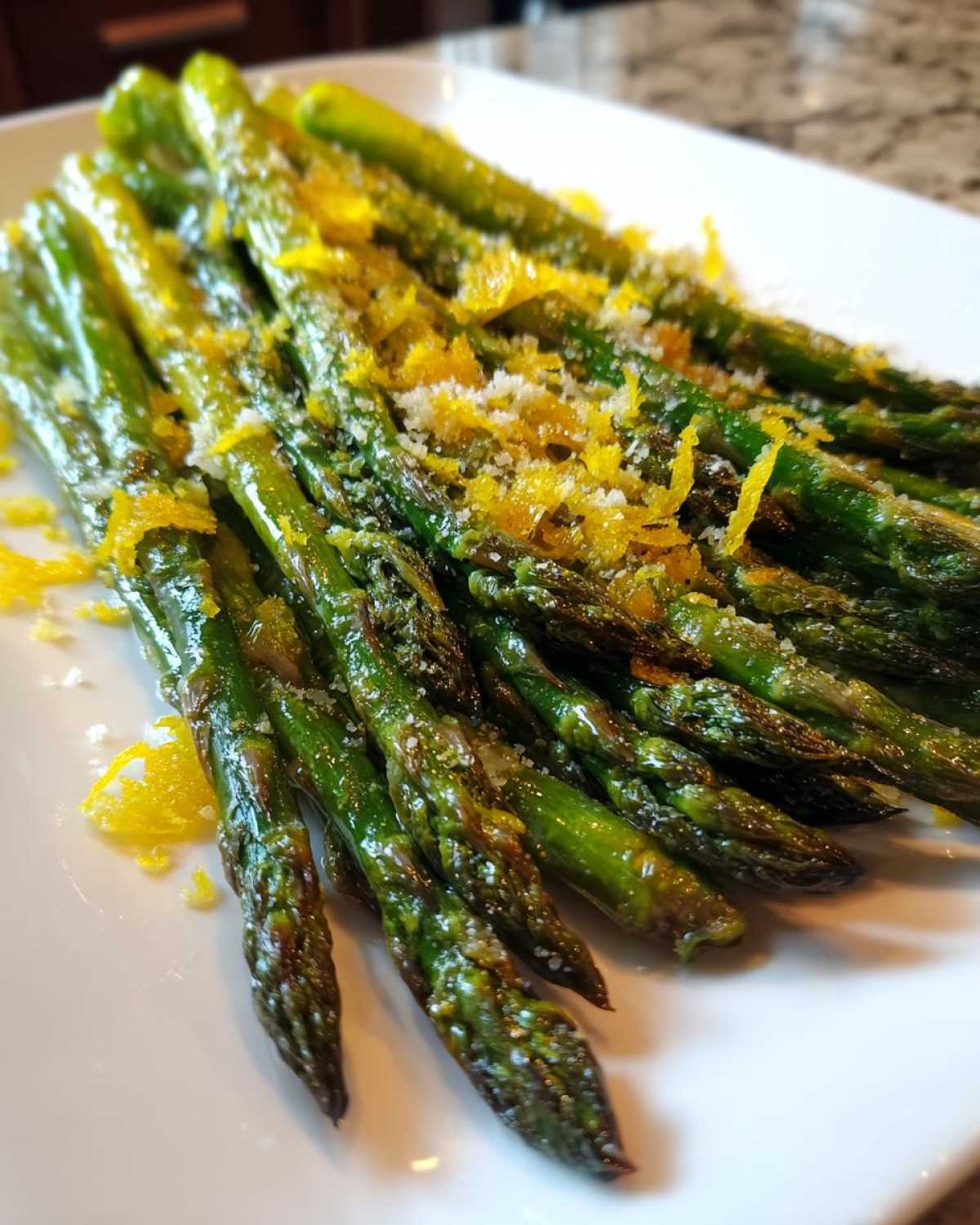 Close-up of bright green Roasted Asparagus with Lemon and Parmesan sprinkled on top.