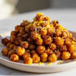 A mound of crispy Lemon Parmesan Roasted Chickpeas sprinkled with bright yellow lemon zest and white Parmesan cheese.