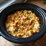 Close-up of creamy Mexican Street Corn Dip Crock Pot recipe, topped with chili powder and cilantro.