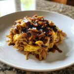 A serving of Moo Shu Chicken Authentic Chinese Stir Fry Dinner featuring shredded chicken and scrambled egg topped with dark sauce.