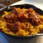 Close-up of flavorful One Pan Tandoori Chicken & Rice served in a black cast iron skillet.
